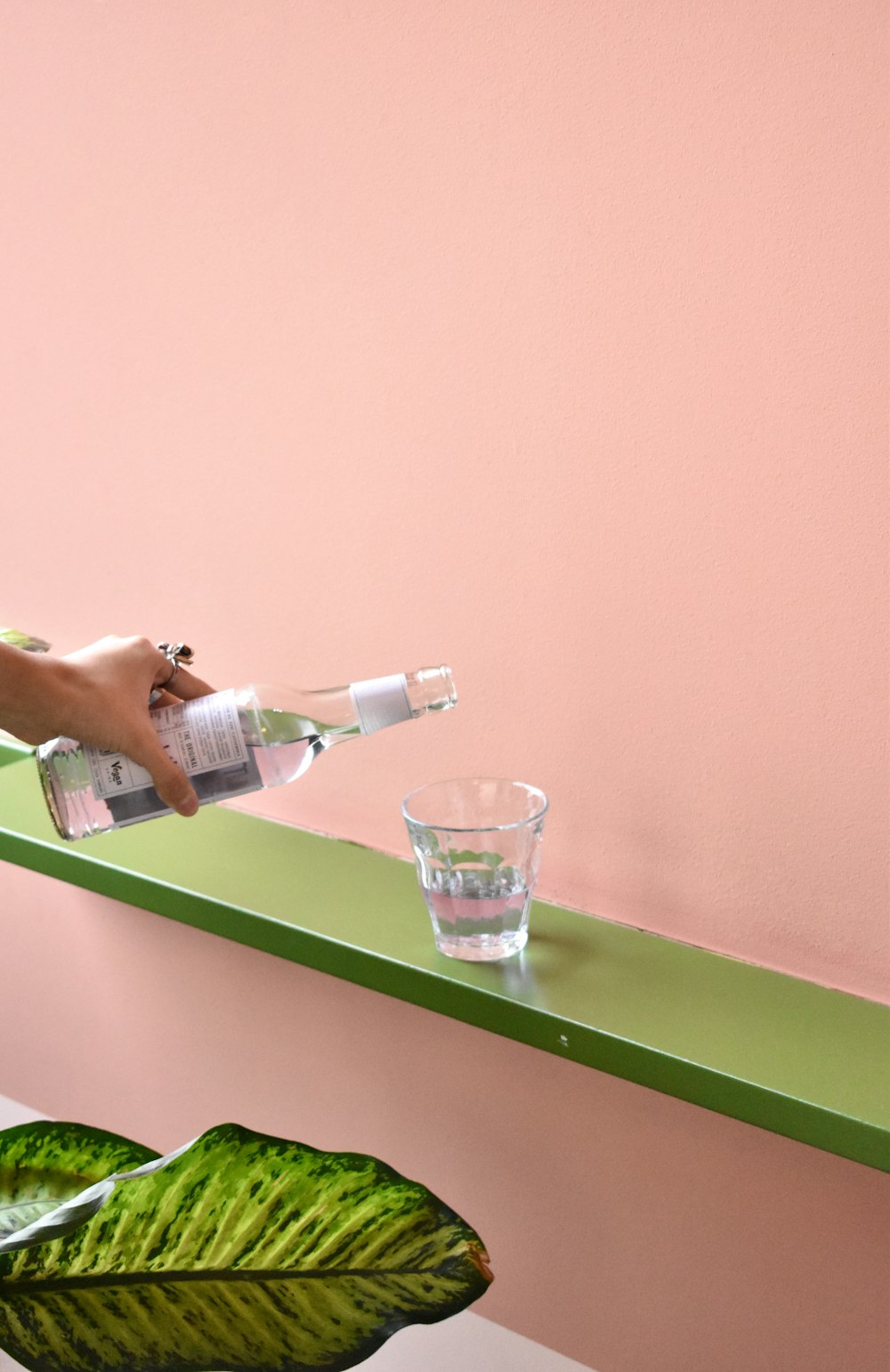 a person pouring water into a glass on a shelf