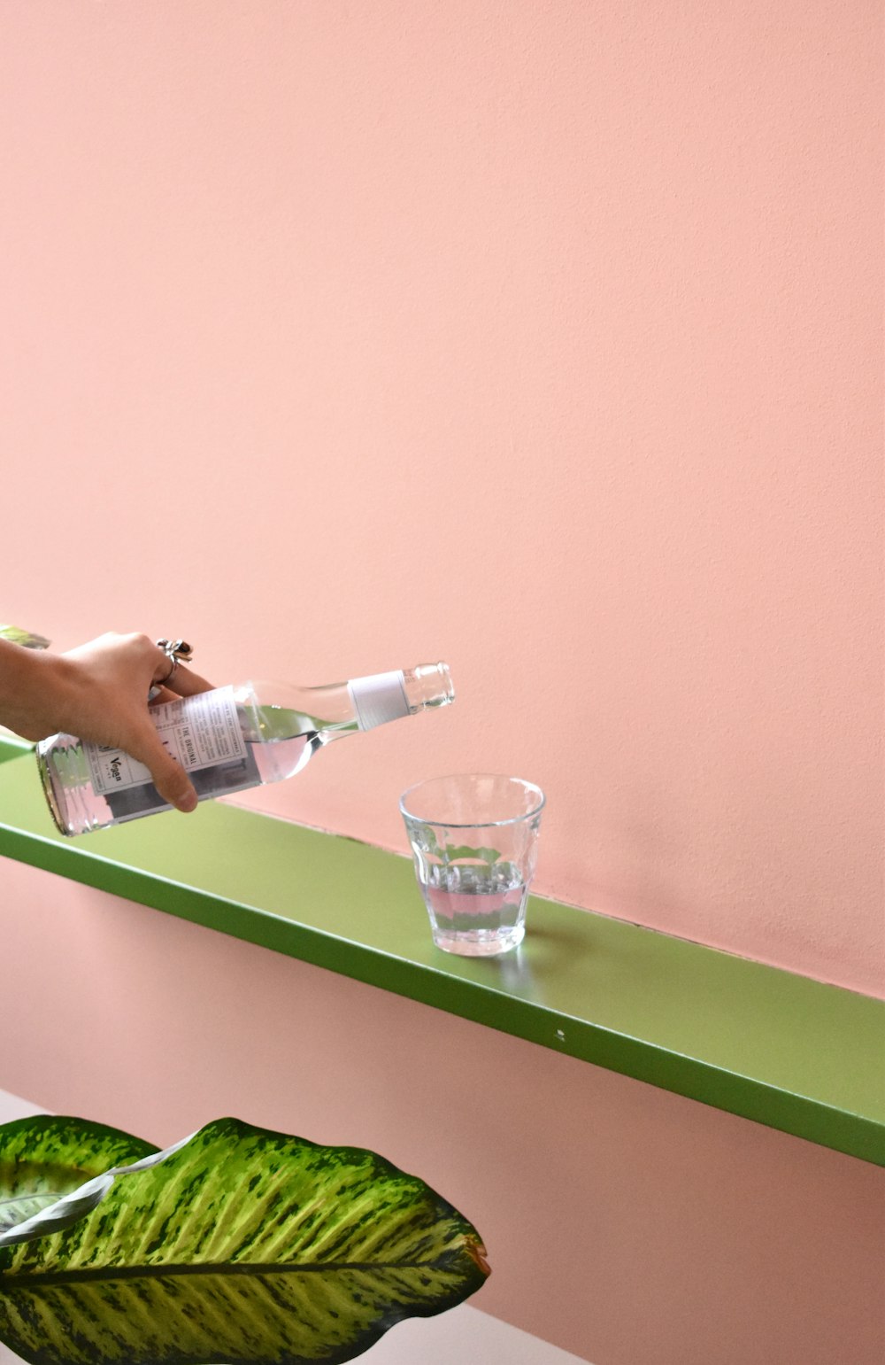 Una persona vertiendo agua en un vaso en un estante