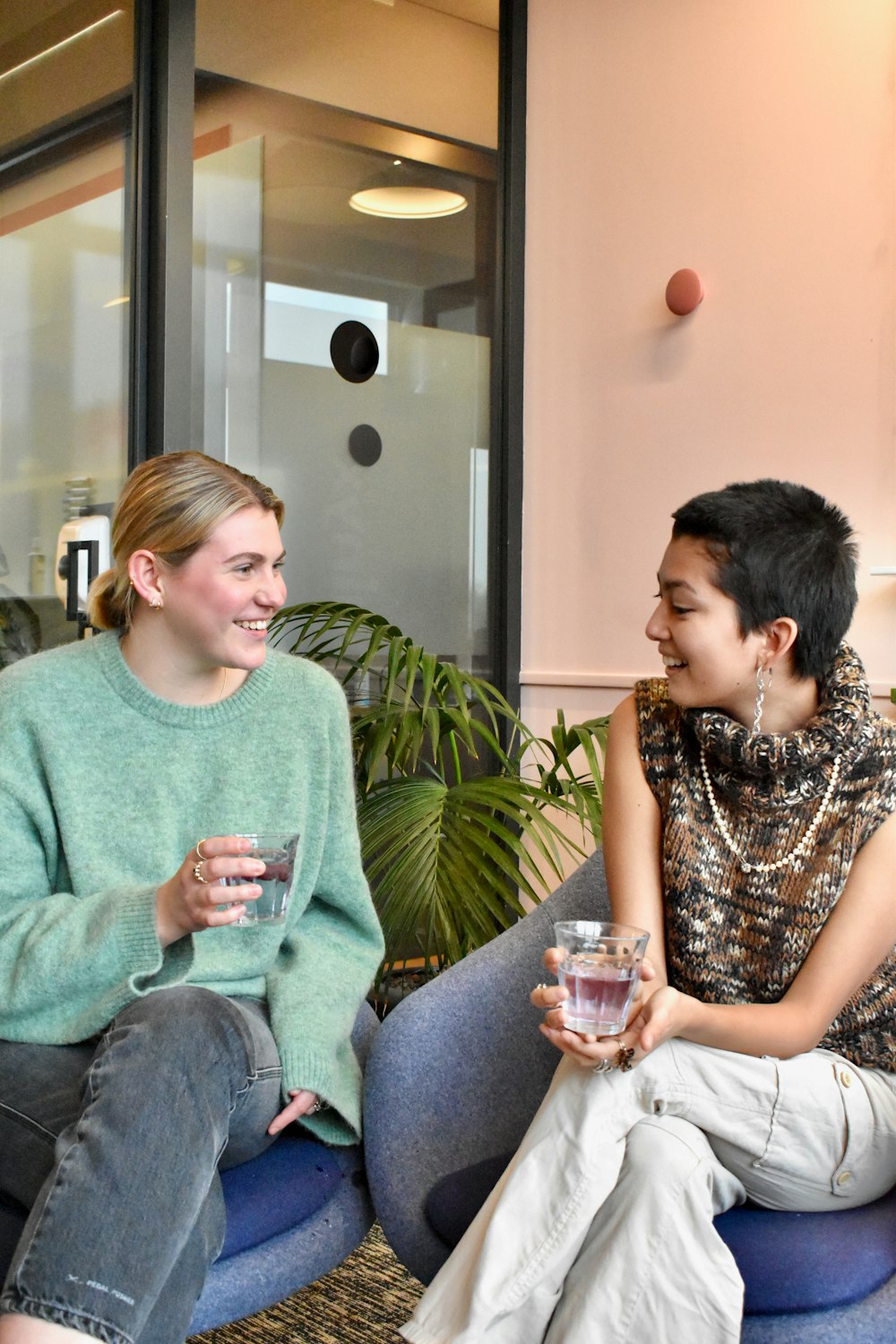 a couple of women sitting on top of a blue couch