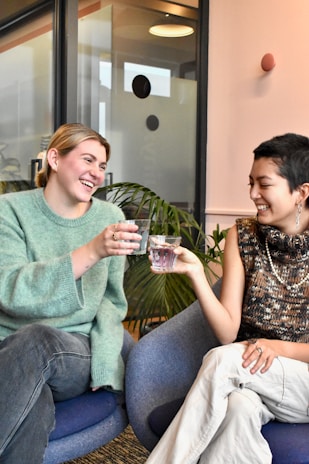 a couple of women sitting on top of a blue chair