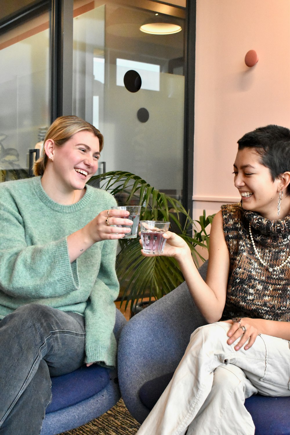 a couple of women sitting on top of a blue chair