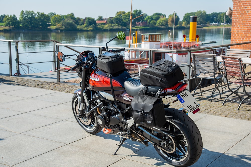 a motorcycle parked on a sidewalk next to a body of water