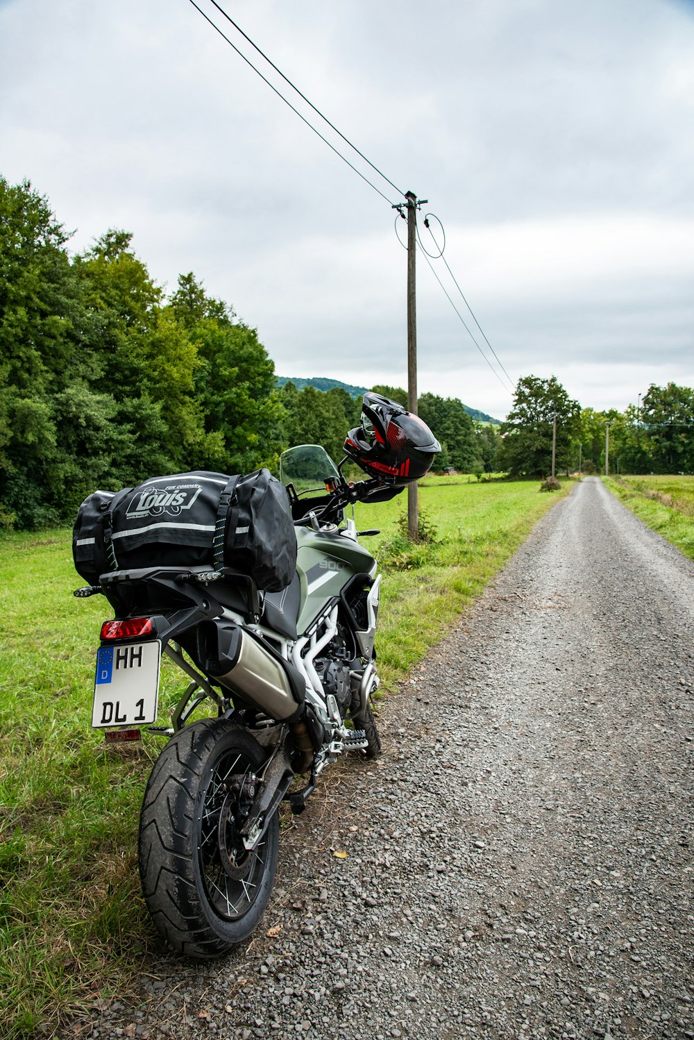 a motorcycle parked on the side of a dirt road