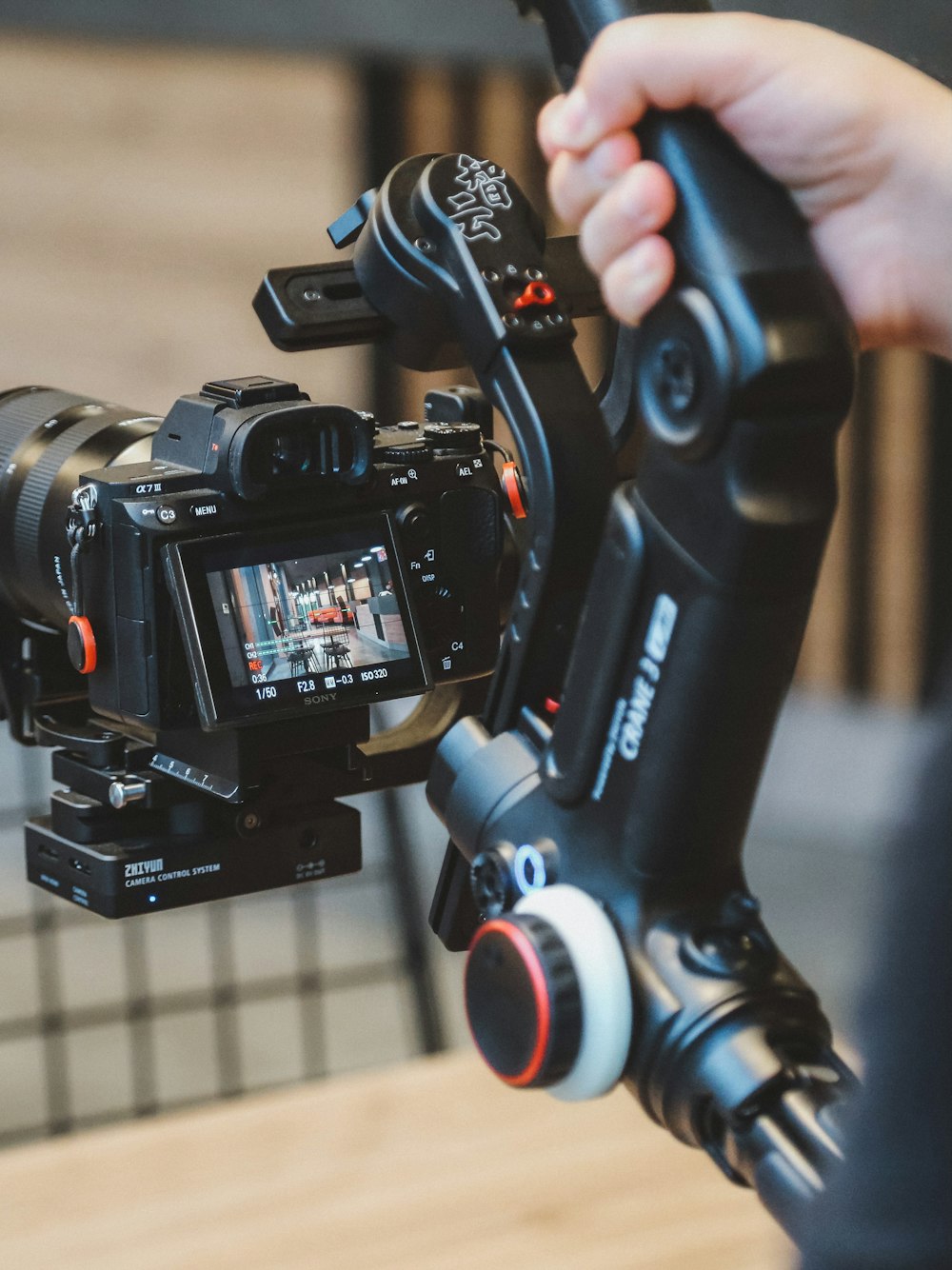 a person holding a video camera on a tripod