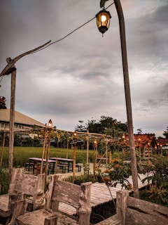 Cozy outdoor seating area under a wooden pergola with hanging lanterns.