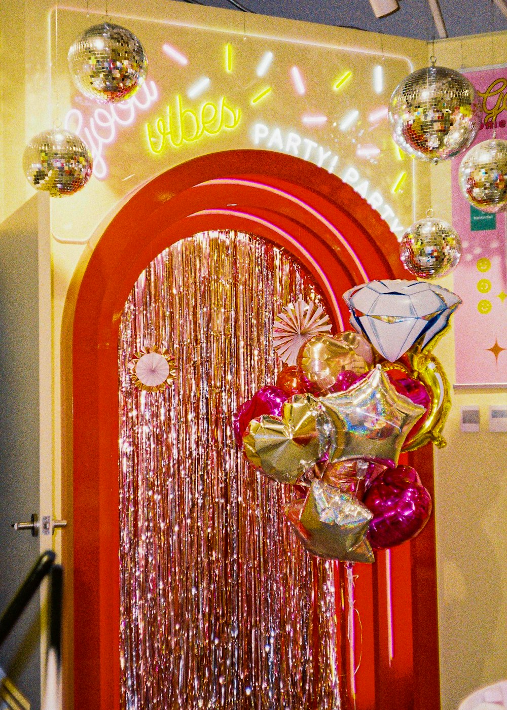 a bunch of balloons hanging from a red door