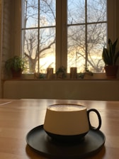 A cozy kitchen scene featuring a minimalist ceramic mug filled with steaming coffee.