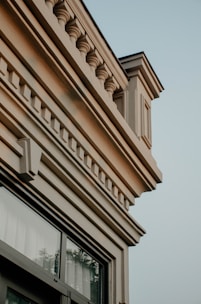 Construction workers carefully applying decorative plaster details on a modern building facade.
