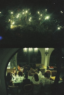 A scenic outdoor party with soft lighting and relaxed conversations under string lights in the club's garden area.