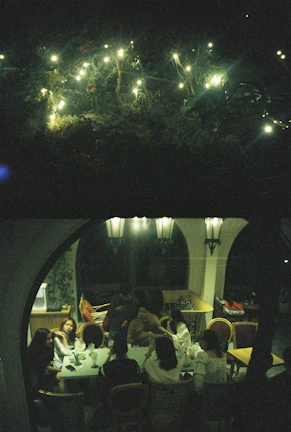 Guests mingling outdoors under soft bronze lighting during a private celebration.