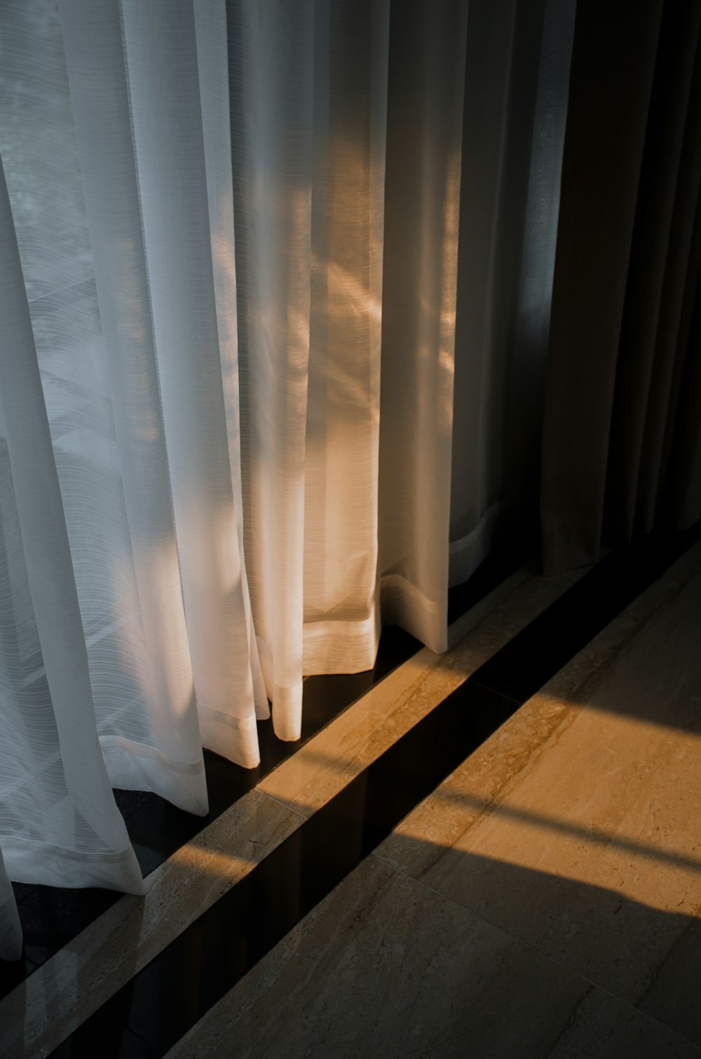 the shadow of a curtain is cast on the floor