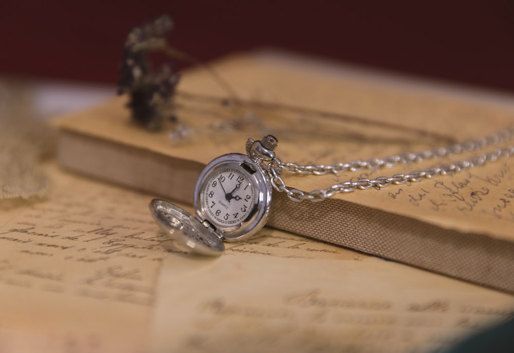 a pocket watch sitting on top of a piece of paper