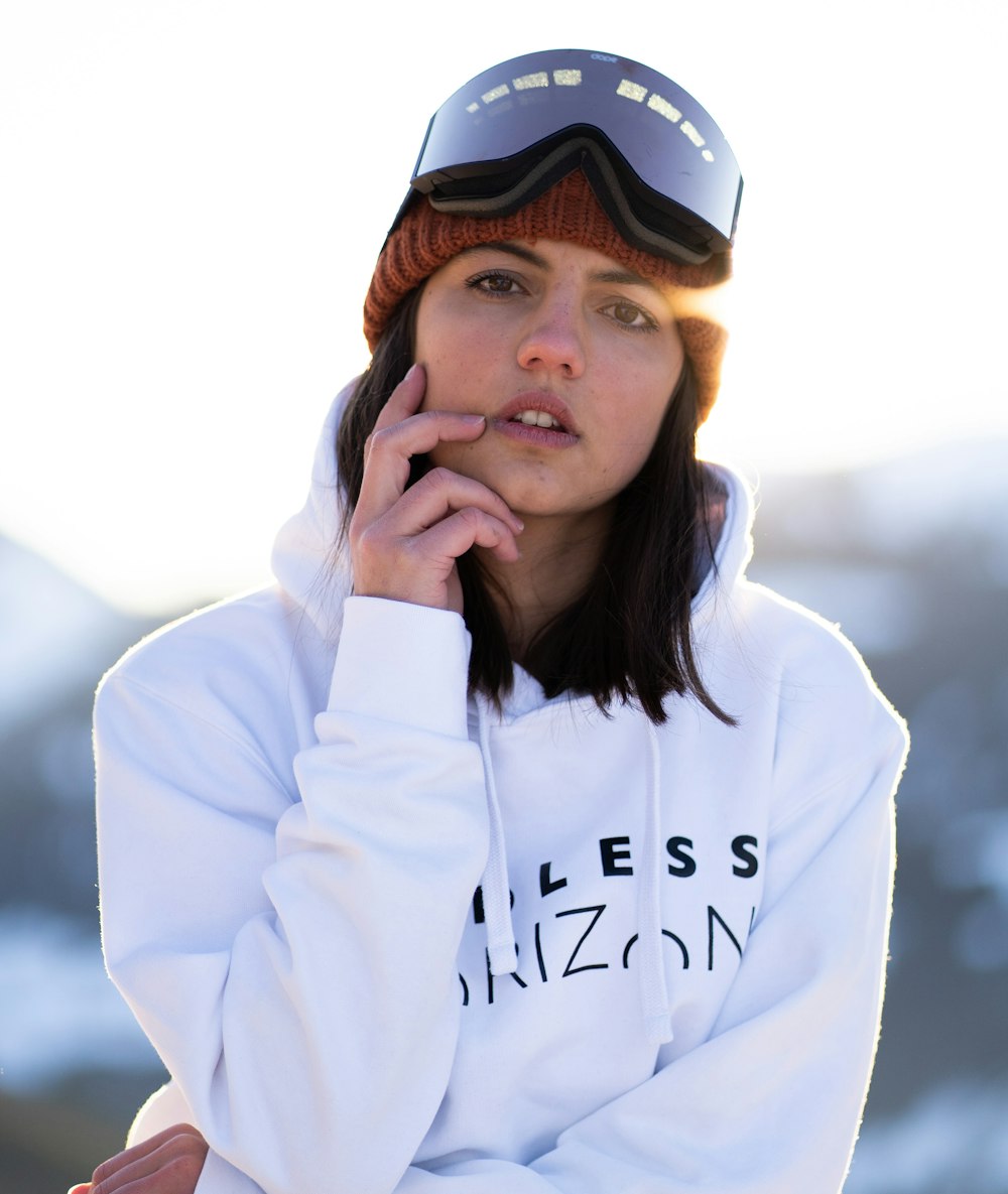 a woman in a white hoodie with a snowboard on her head