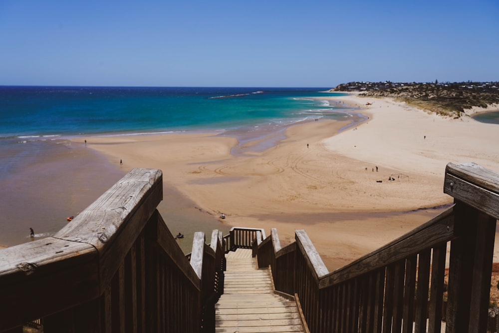 a stairway leading down to a sandy beach