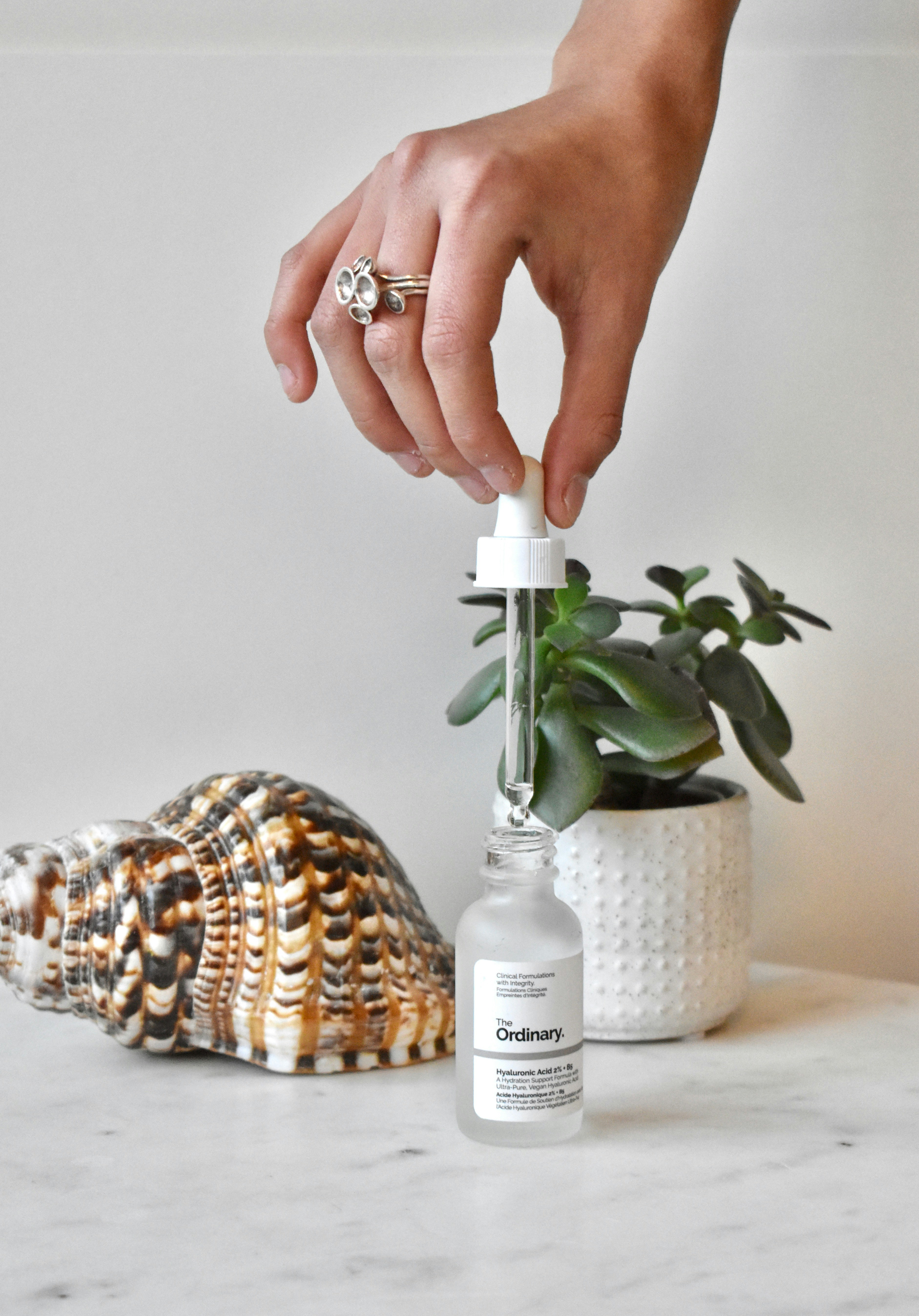 Une main tient une petite bouteille avec une petite quantité de liquide dedans