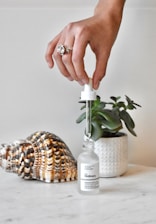 a hand is holding a small bottle with a small amount of liquid in it