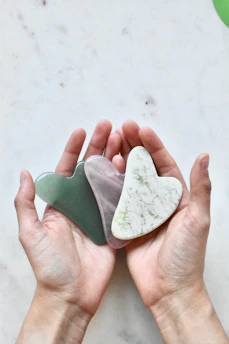 Close-up of hands gently holding a heart-shaped stone symbolizing care.