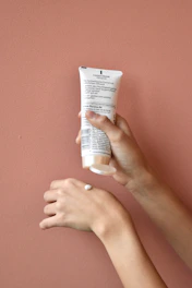 Close-up of hands applying soothing Korean hand cream with floral packaging.