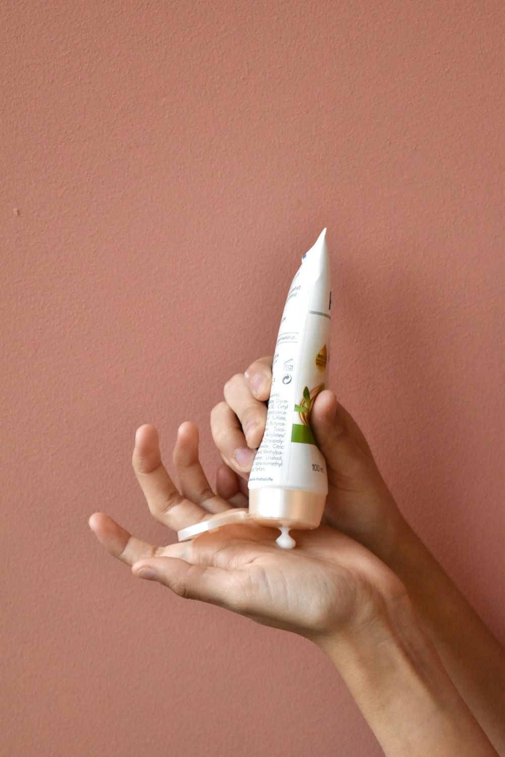 a person holding a tube of toothpaste in their hand