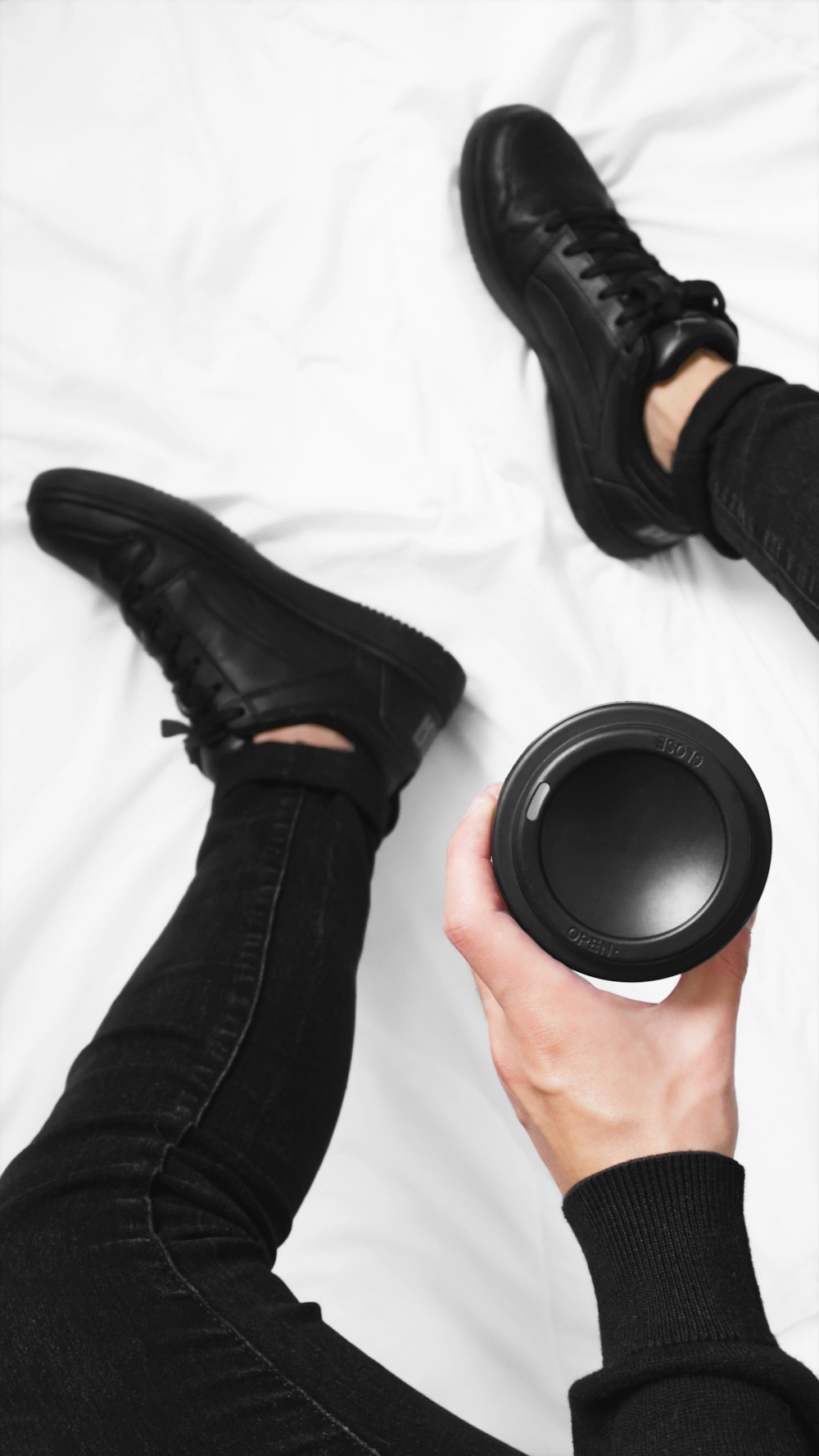 a person laying on a bed holding a black object