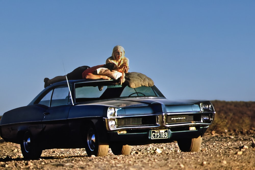 a man sitting on the hood of a car