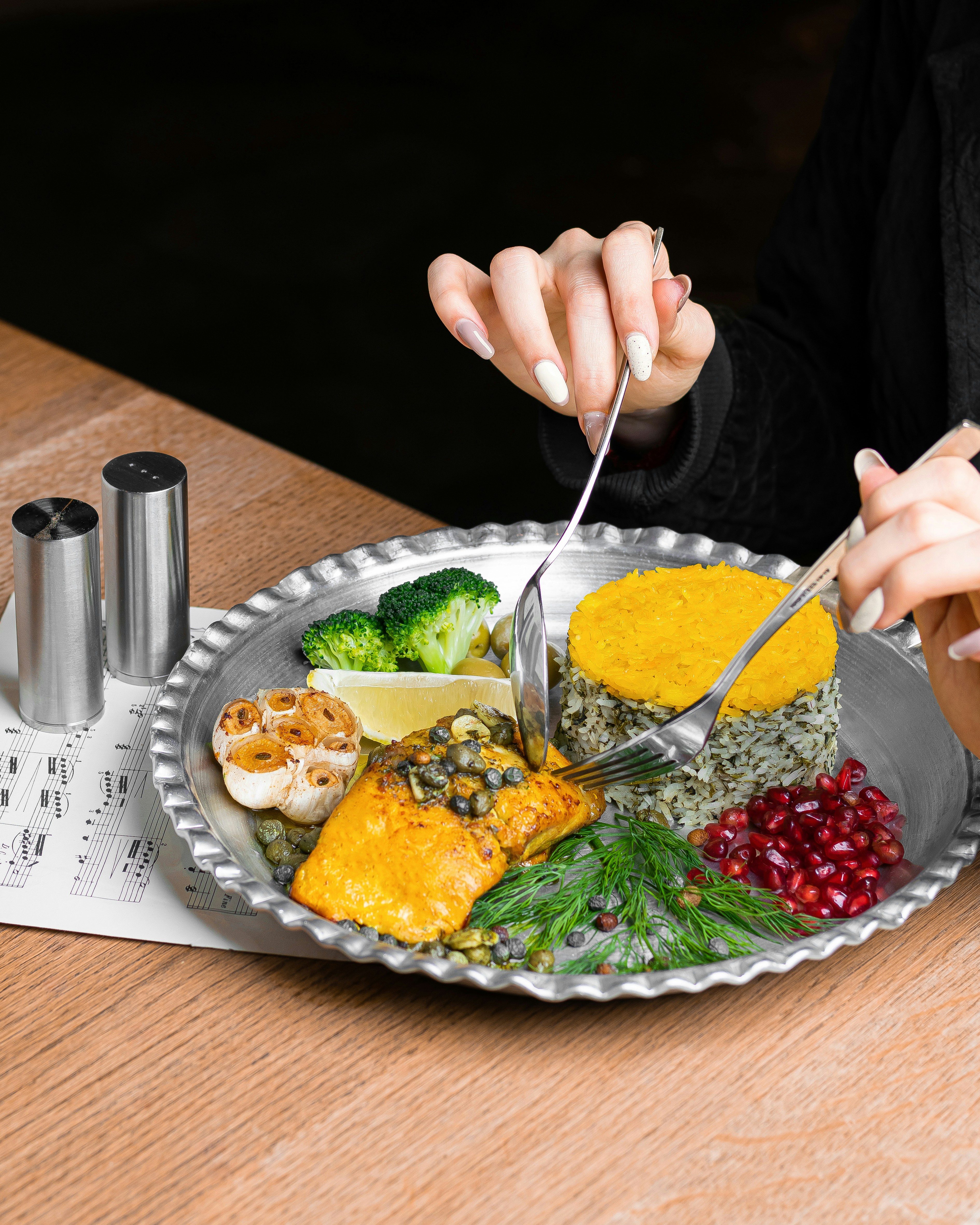 a woman is cutting into a plate of food