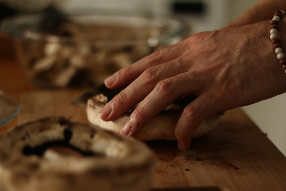 a person with their hand on a piece of bread