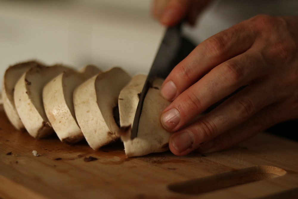 a person cutting up some food on a cutting board