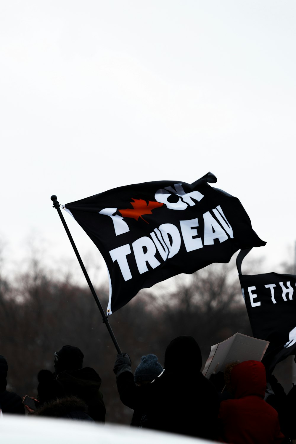 a group of people holding a black and white flag