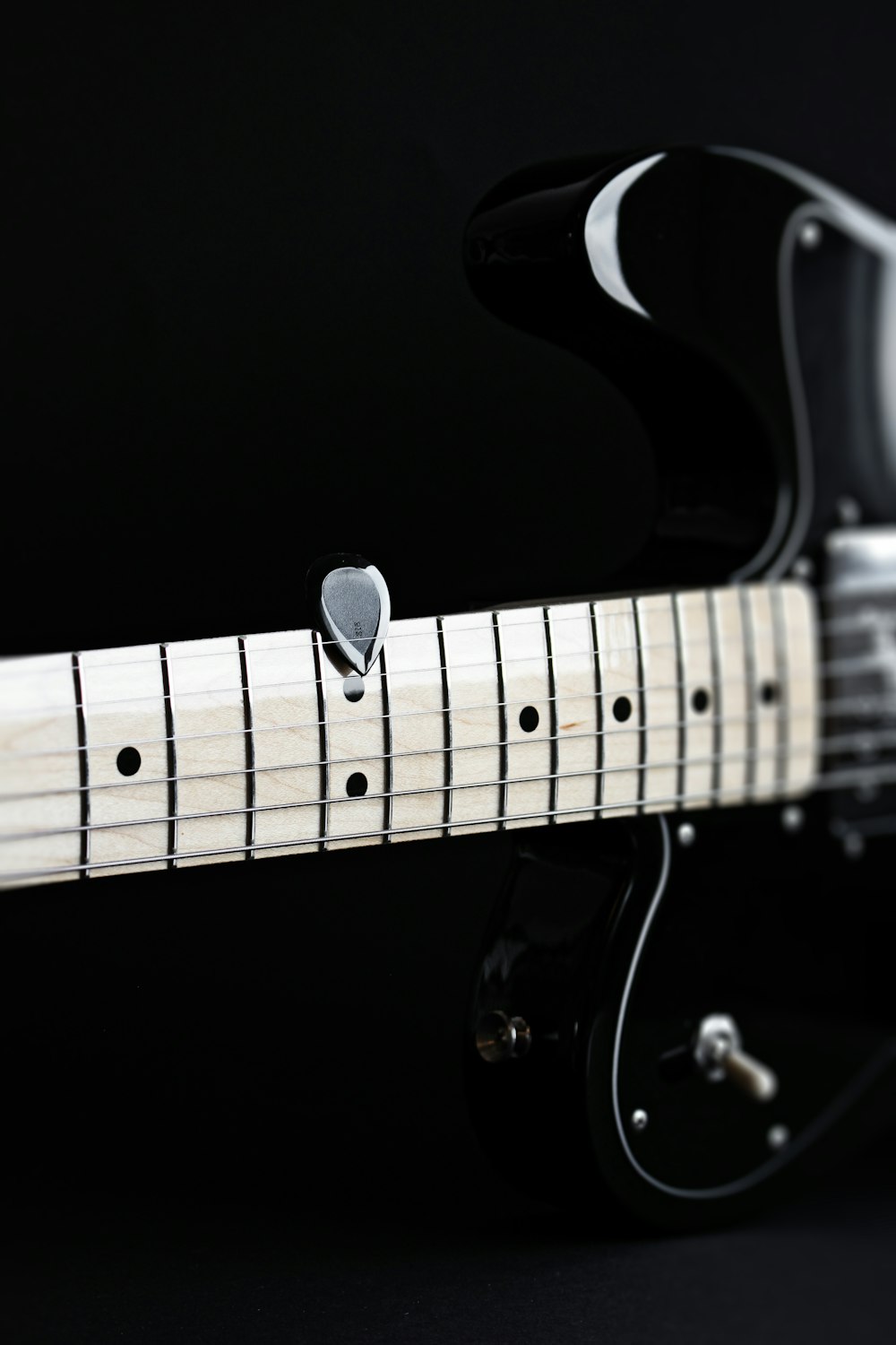 a close up of an electric guitar with a black background