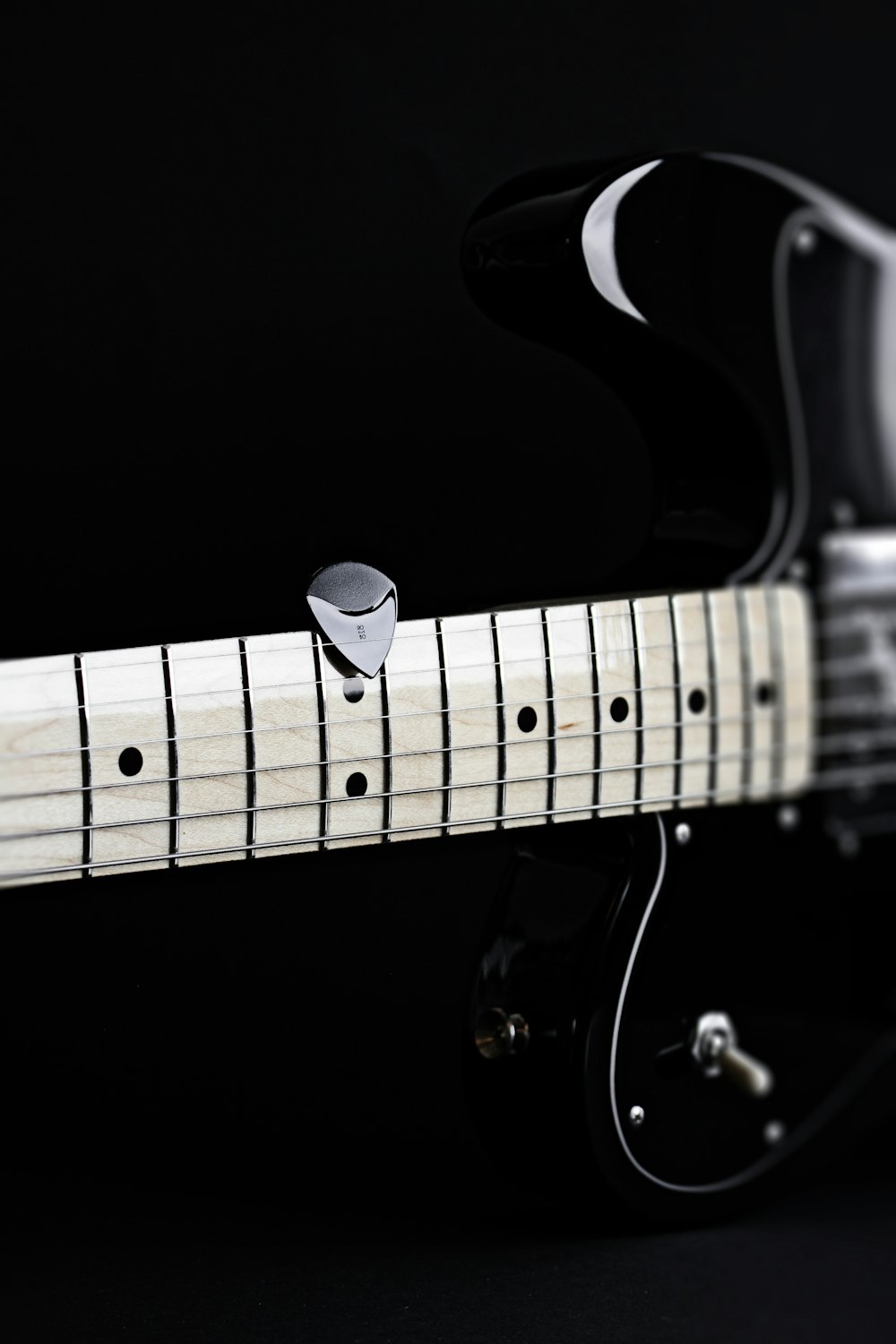 a close up of a black and white electric guitar