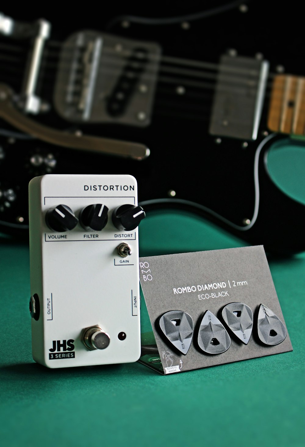 a close up of a guitar pedal and a guitar