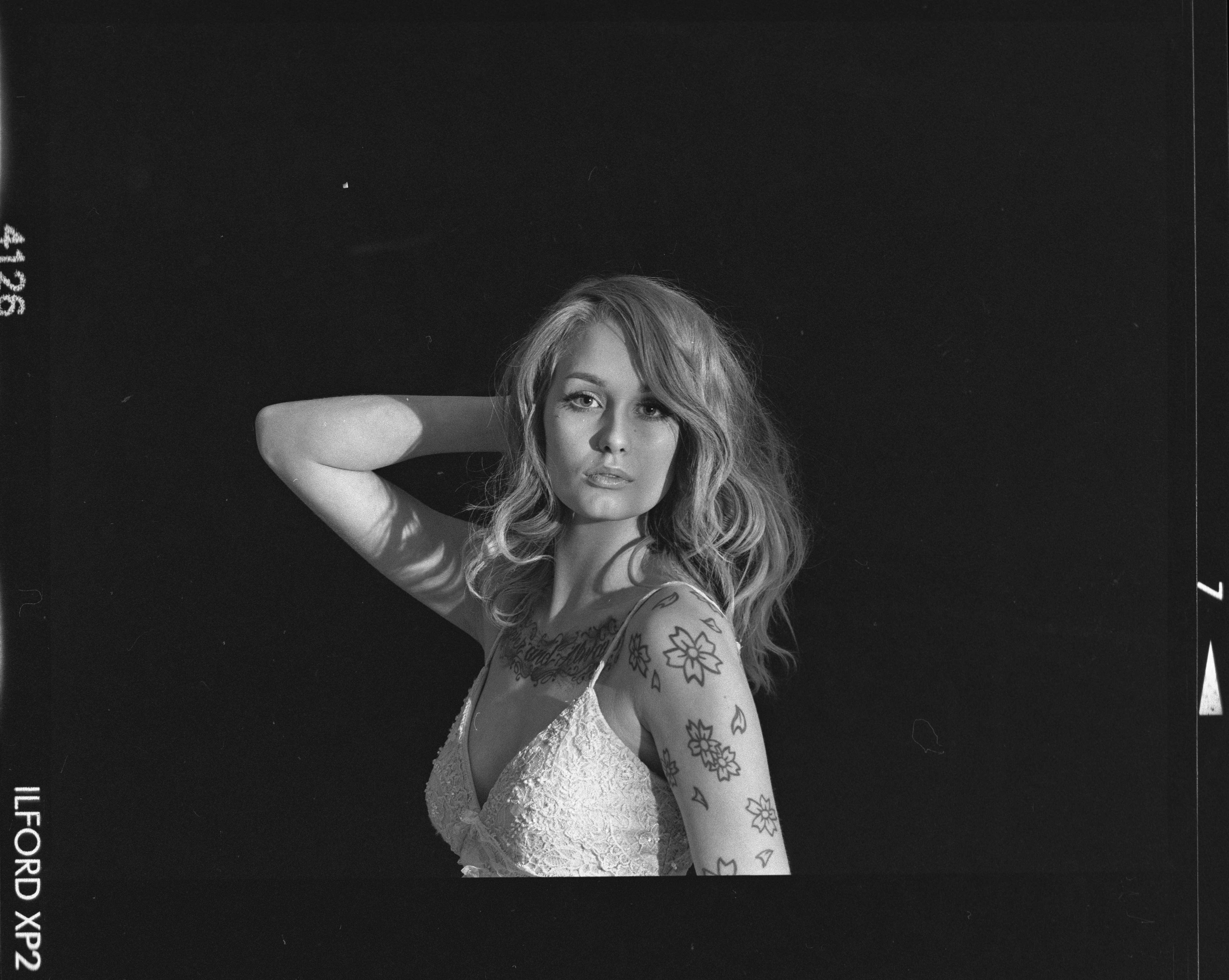 a black and white photo of a woman with tattoos