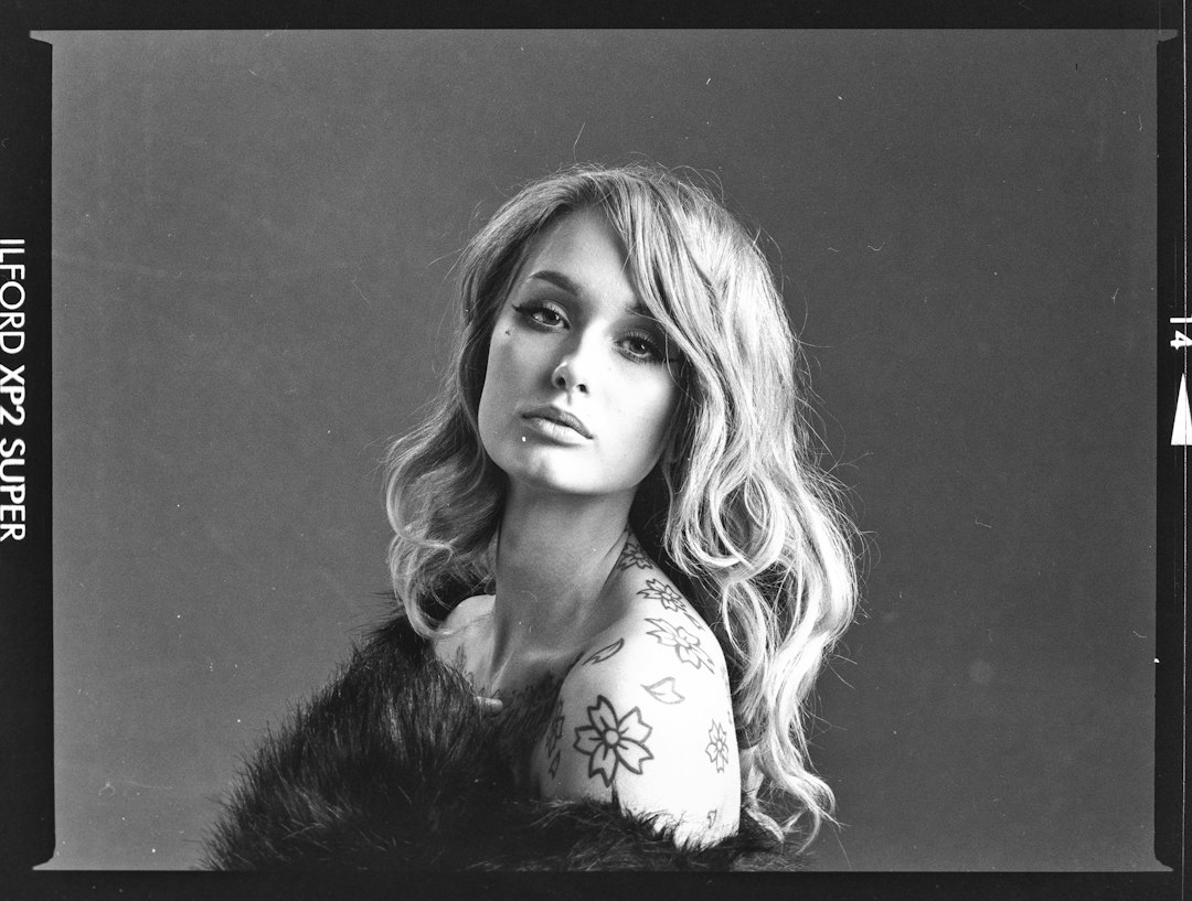 a black and white photo of a woman with tattoos