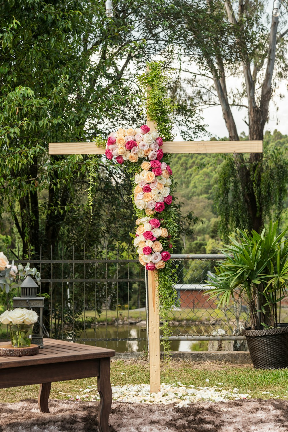 a cross decorated with flowers and a basket of flowers