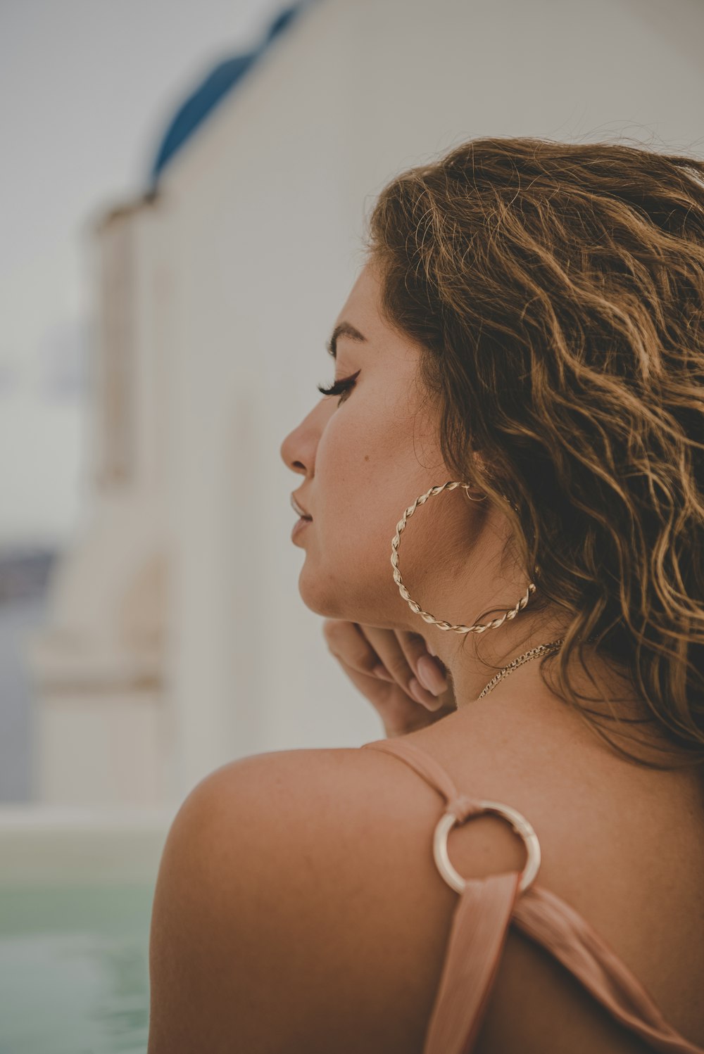 a woman with large hoop earrings standing in a pool