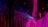 An abstract digital artwork featuring vibrant streaks and splashes of pink, blue, and purple against a predominantly black background. The pattern resembles a chaotic yet structured accumulation of vertical lines and scattered pixels, creating a vivid sense of movement and depth.