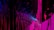 An abstract digital artwork featuring vibrant streaks and splashes of pink, blue, and purple against a predominantly black background. The pattern resembles a chaotic yet structured accumulation of vertical lines and scattered pixels, creating a vivid sense of movement and depth.