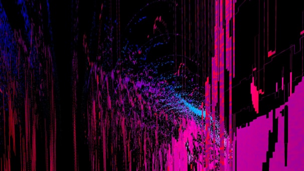 An abstract digital artwork featuring vibrant streaks and splashes of pink, blue, and purple against a predominantly black background. The pattern resembles a chaotic yet structured accumulation of vertical lines and scattered pixels, creating a vivid sense of movement and depth.