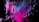 An abstract digital artwork featuring dynamic streaks and blocks of bright colors, predominantly pink and blue, emerging against a black background. The composition gives a sense of movement and fragmentation, with pixel-like patterns creating a vibrant and energetic visual effect.