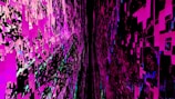 A digital abstract composition featuring a chaotic arrangement of pixelated rectangles and squares in vivid pinks, blacks, and hints of blue. The image features a tunnel-like perspective, giving a sense of depth and immersion.