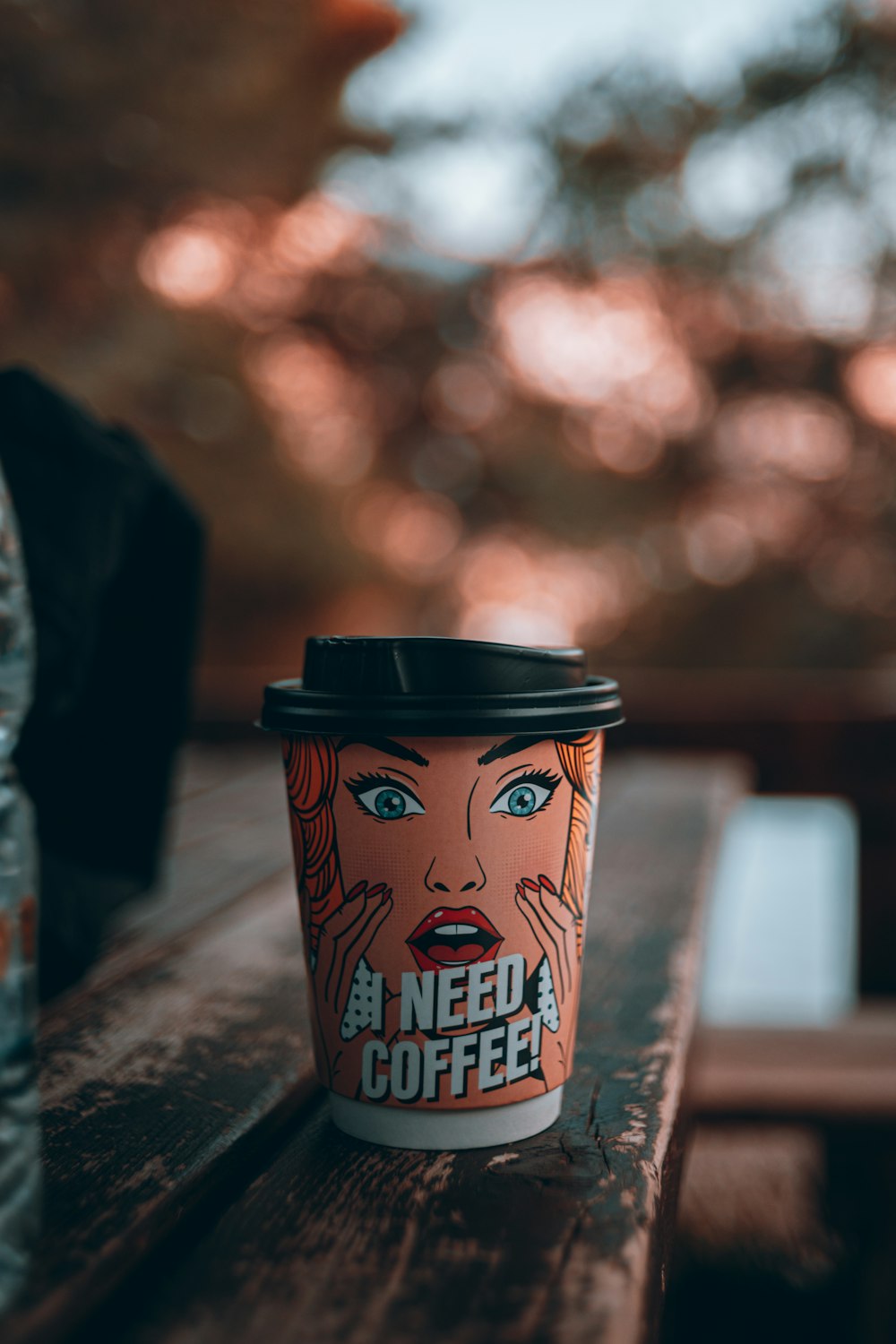 a cup of coffee sitting on top of a wooden table