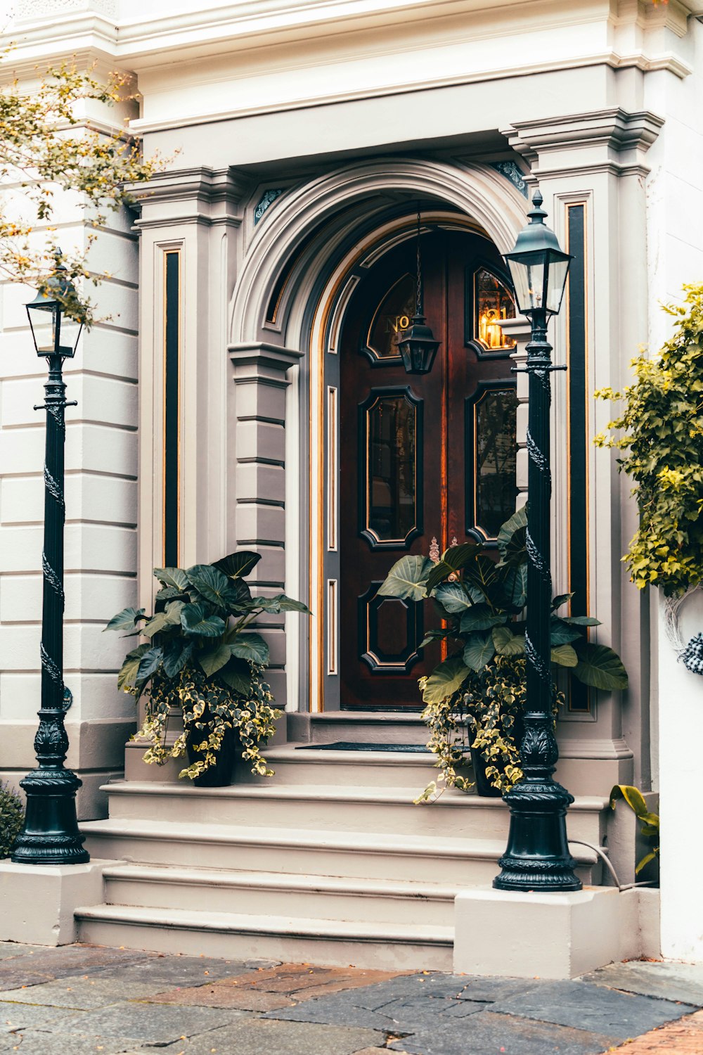 a house with a red door and a black lamp post