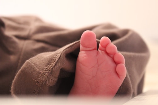 A close-up of a child's foot being examined by a doctor.