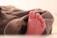 Close-up of a toddler wearing brown low-top soft sole oxfords, taking first steps on a wooden floor.