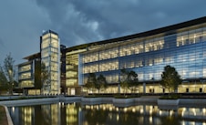 a large glass building sitting next to a body of water