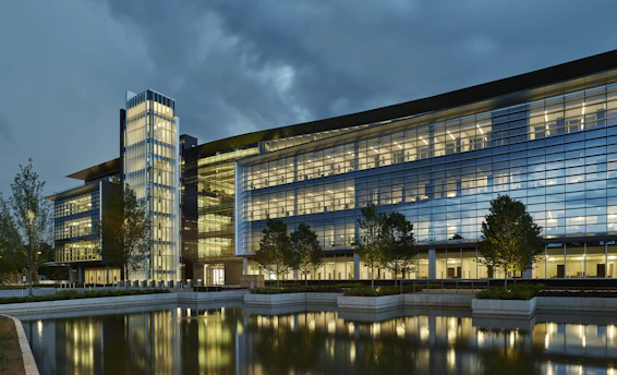 a large glass building sitting next to a body of water