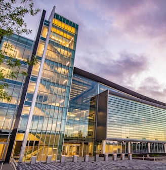 a large glass building sitting under a cloudy sky