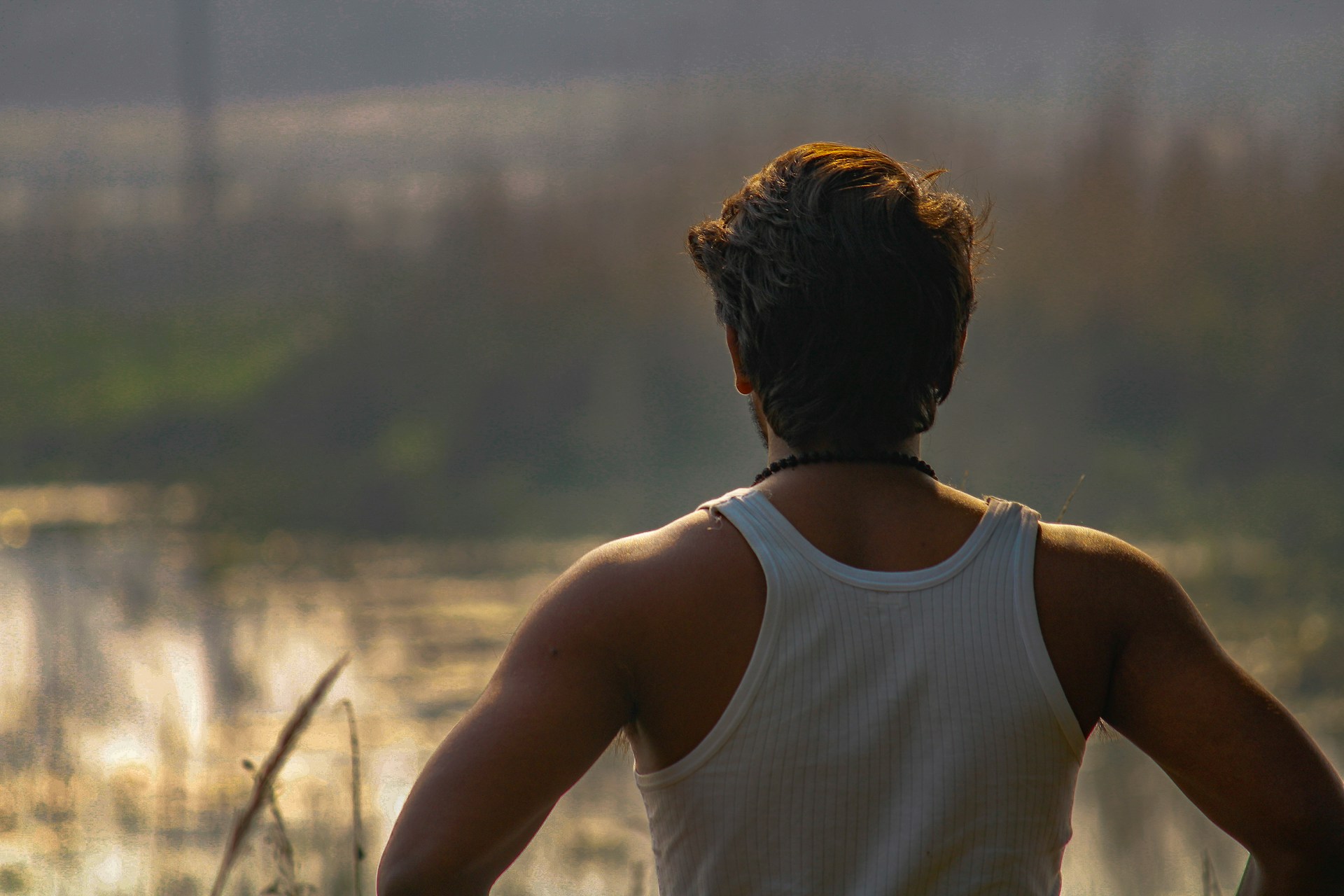 a man standing in front of a body of water