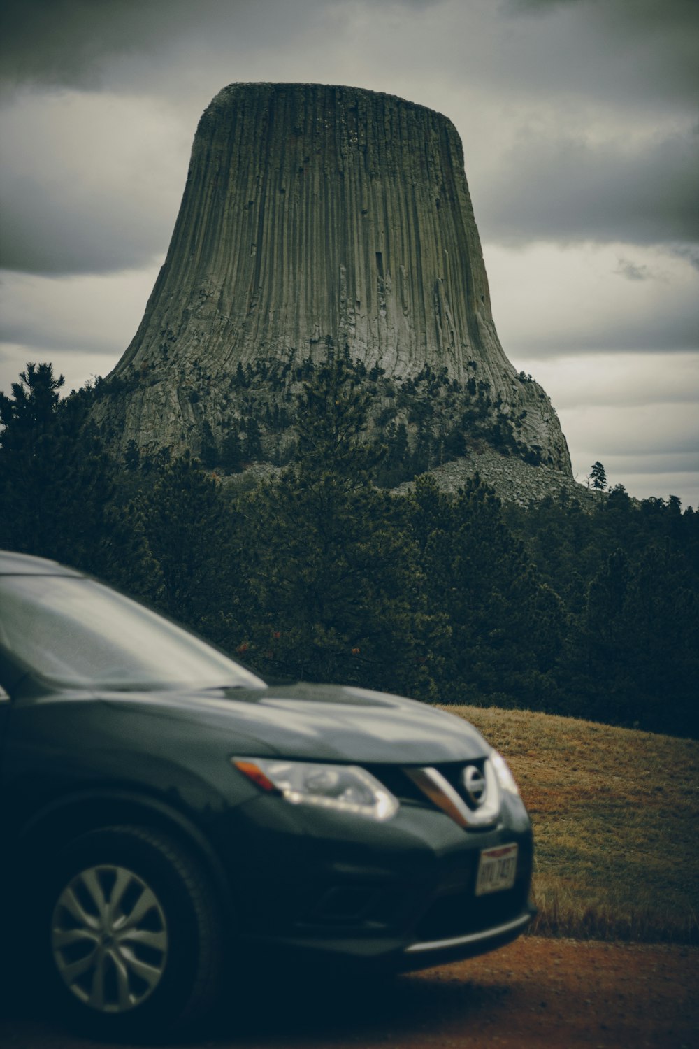 a car parked in front of a large rock formation